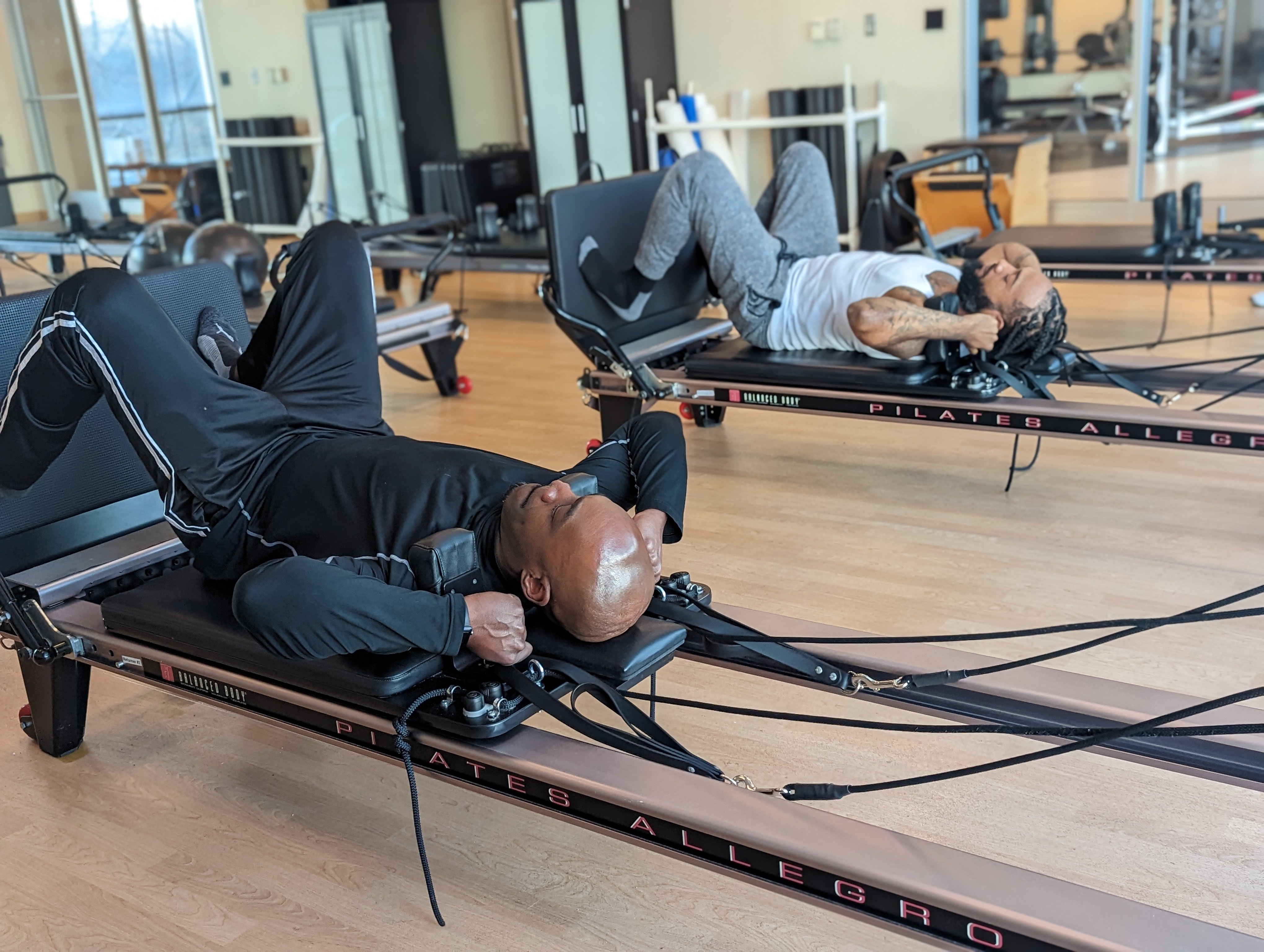 YMCA Two men working out on Reformer Pilates machines